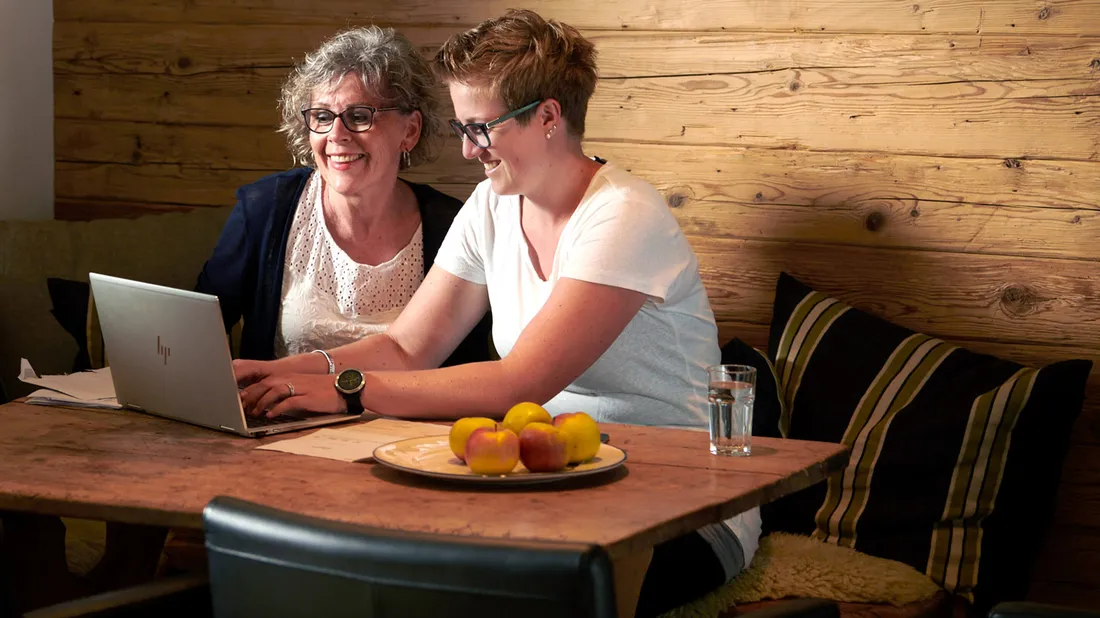 Zwei Frauen mit Laptop am Esstisch