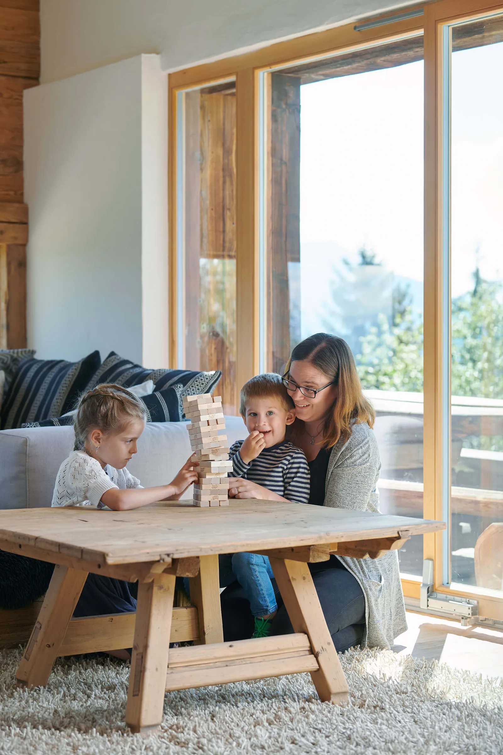 Mutter und Kinder spielen Jenga