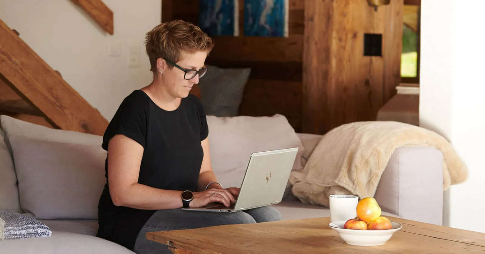 Frau mit Laptop auf dem Sofa