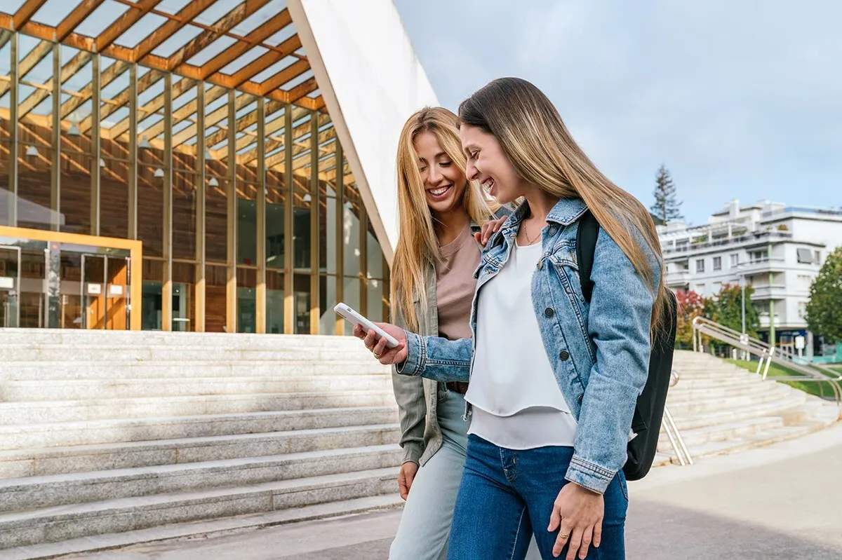 Lachende Frauen mit Blick auf Handy