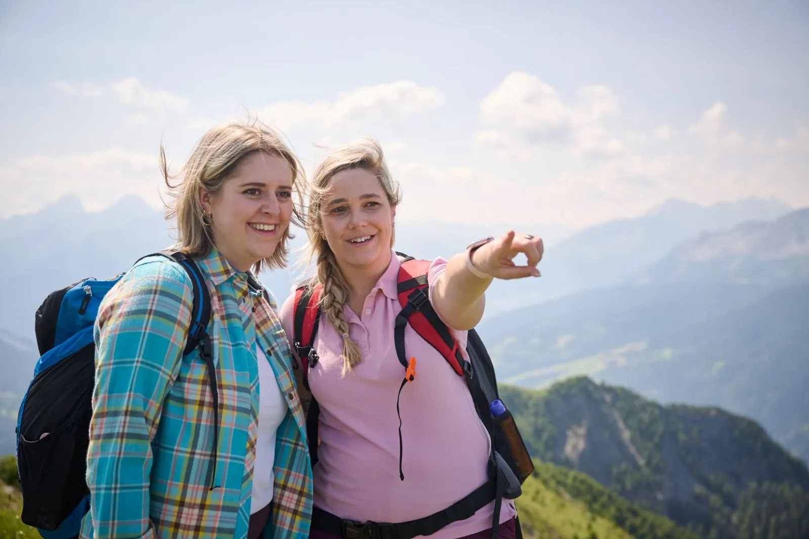 2 Frauen beim Wandern in den Bergen zeigen auf etwas