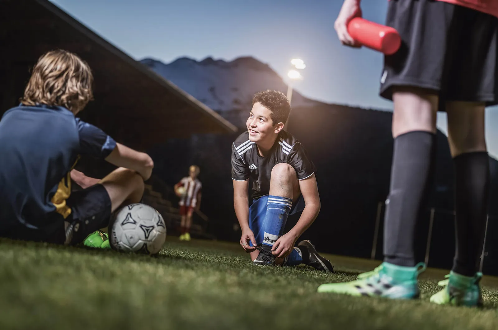 Junge bindet Fussballschuhe