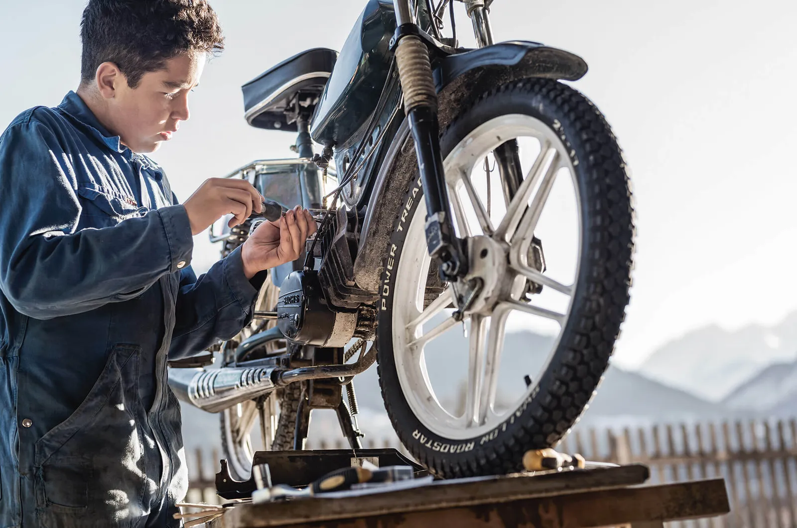 Junge repariert sein Moped