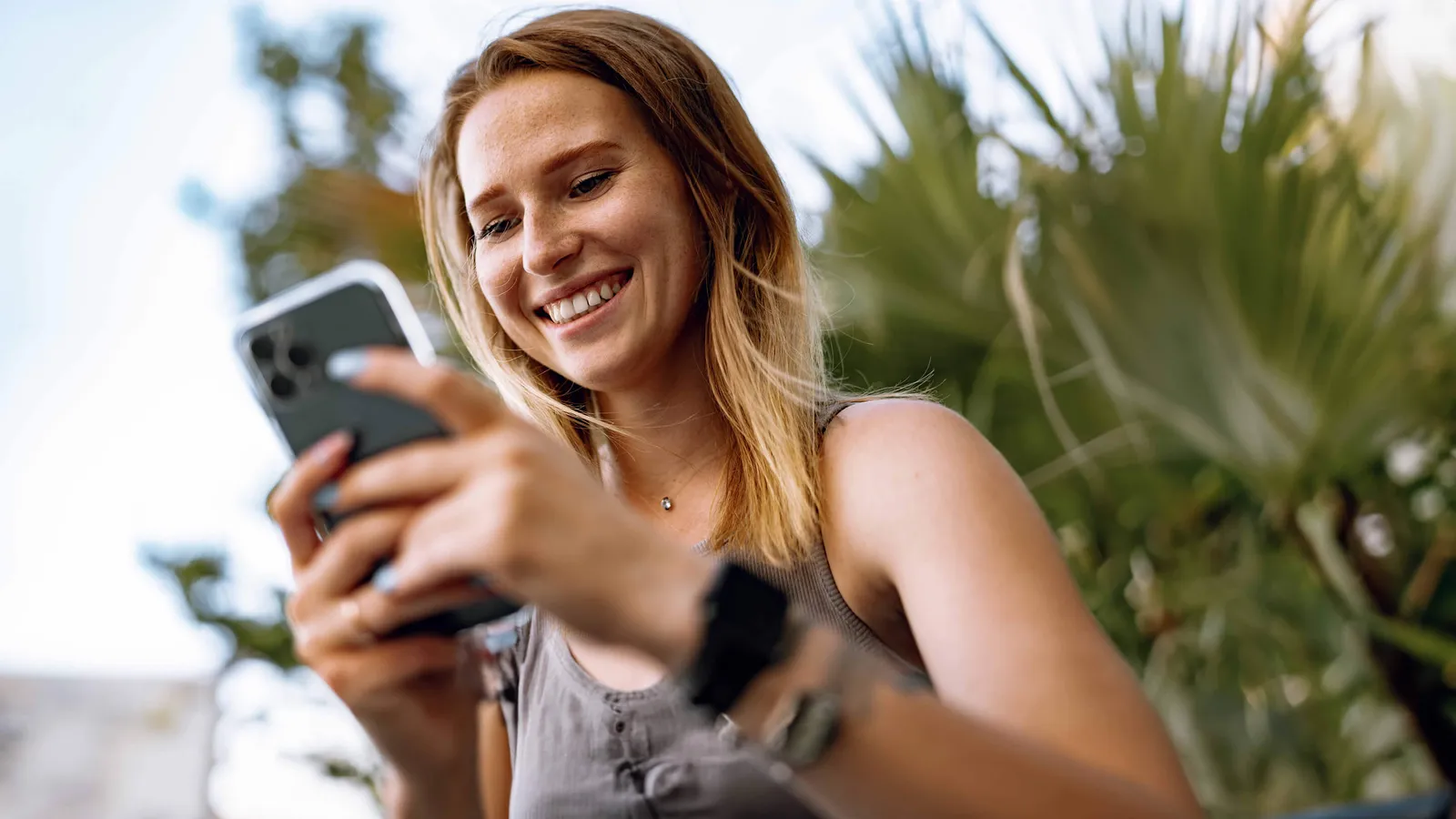 Eine junge Frau blickt auf ihr Smartphone