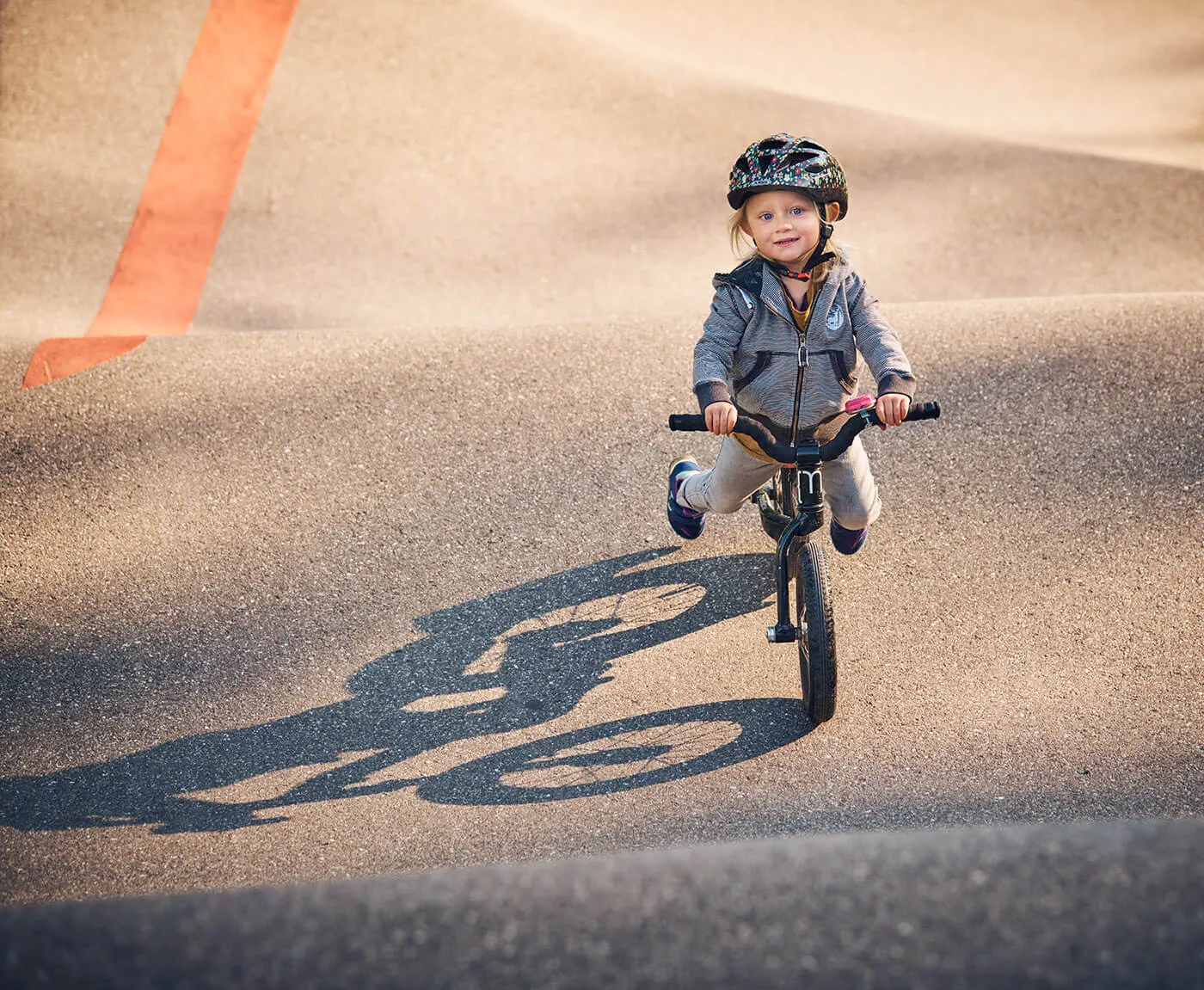 Mädchen mit Velo auf dem Pumptrack