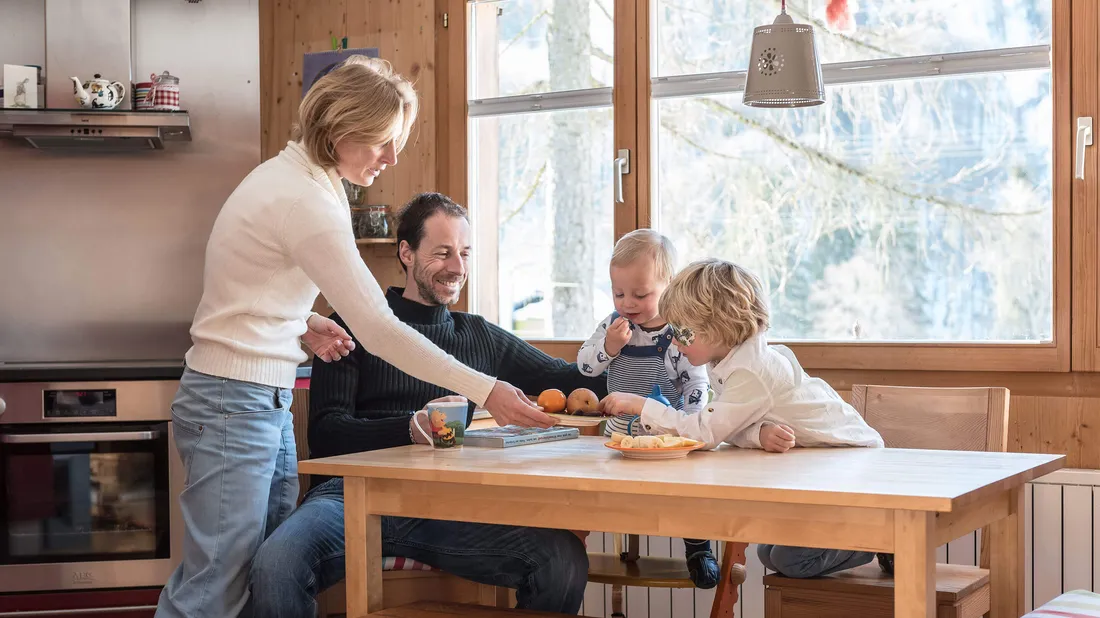 Eine Familie sitzt am Küchentisch