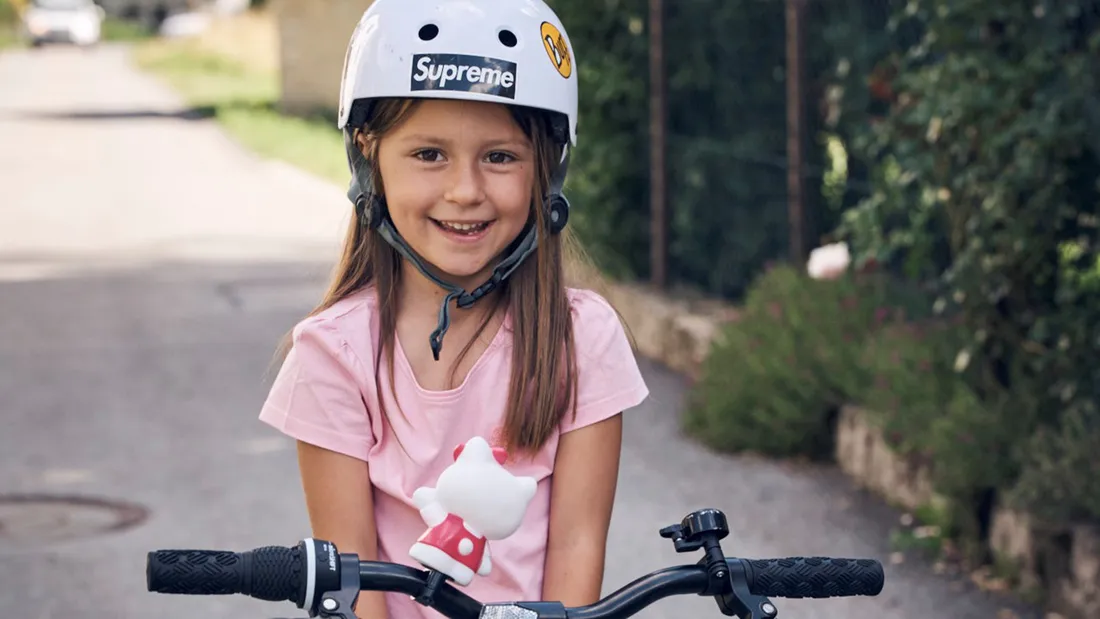 Mädchen mit Helm und Velo ist bereit für den Schulstart