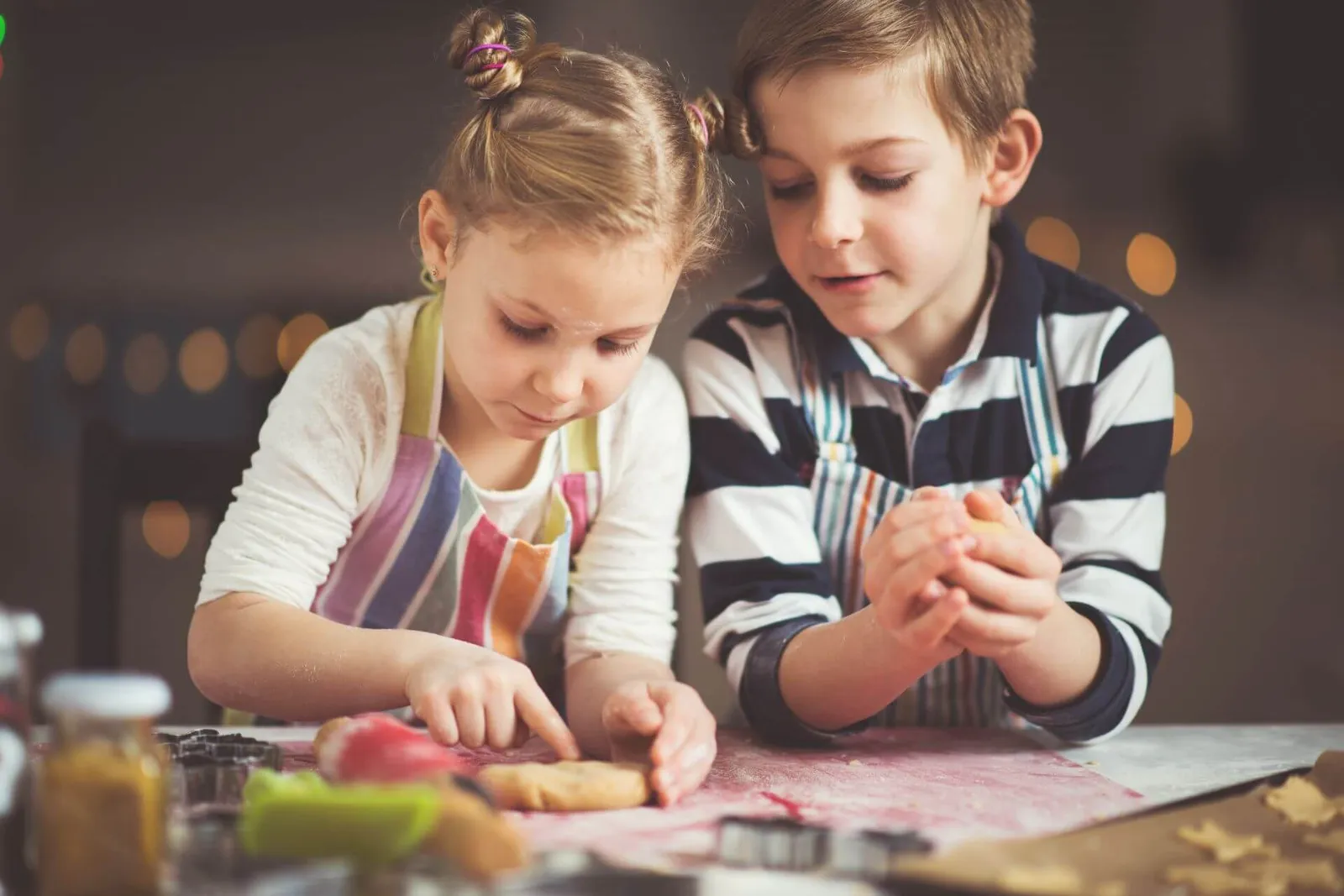 Zwei Kinder backen Weihnachtsguetzli