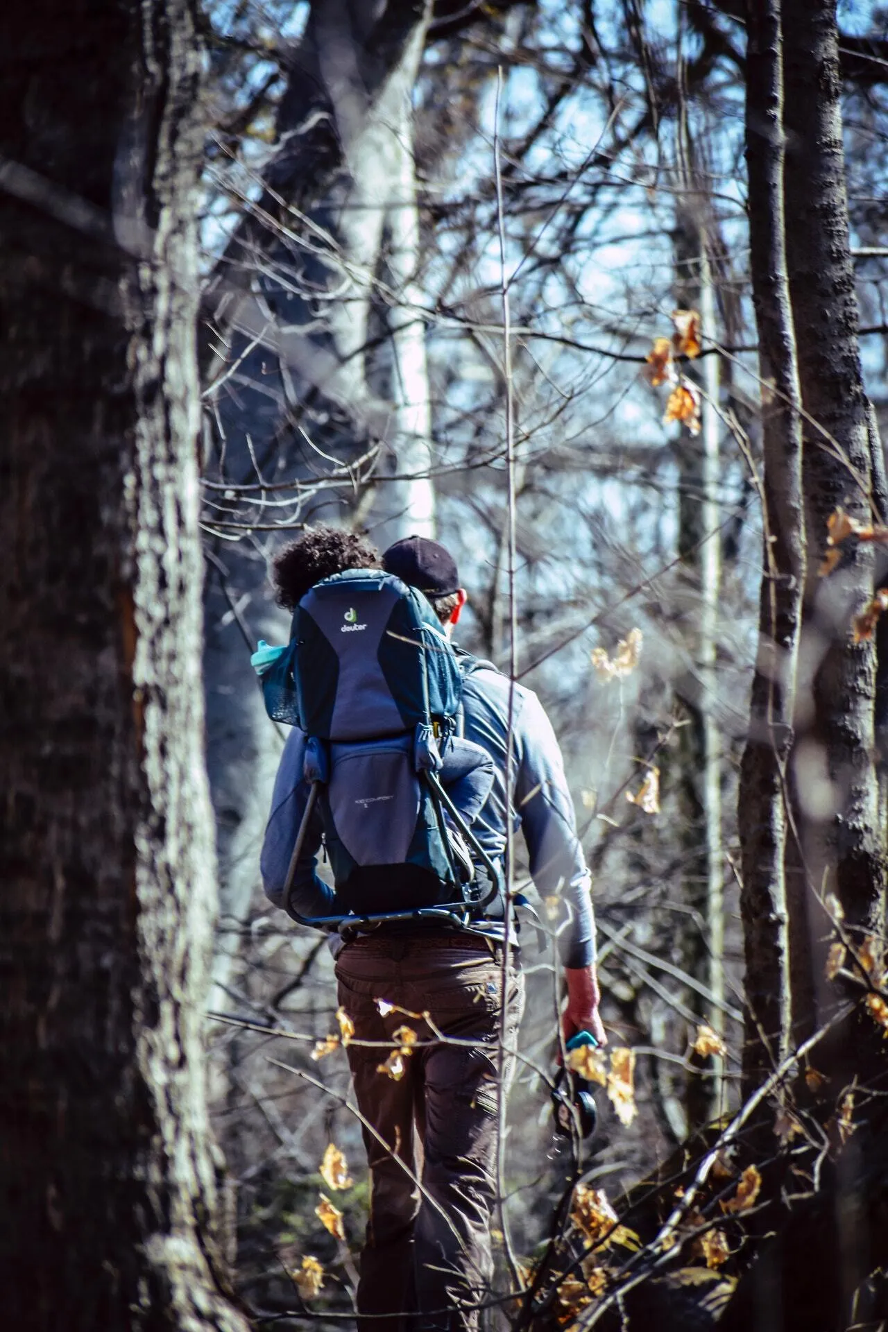 Mann mit Kindertragerucksack im Wald