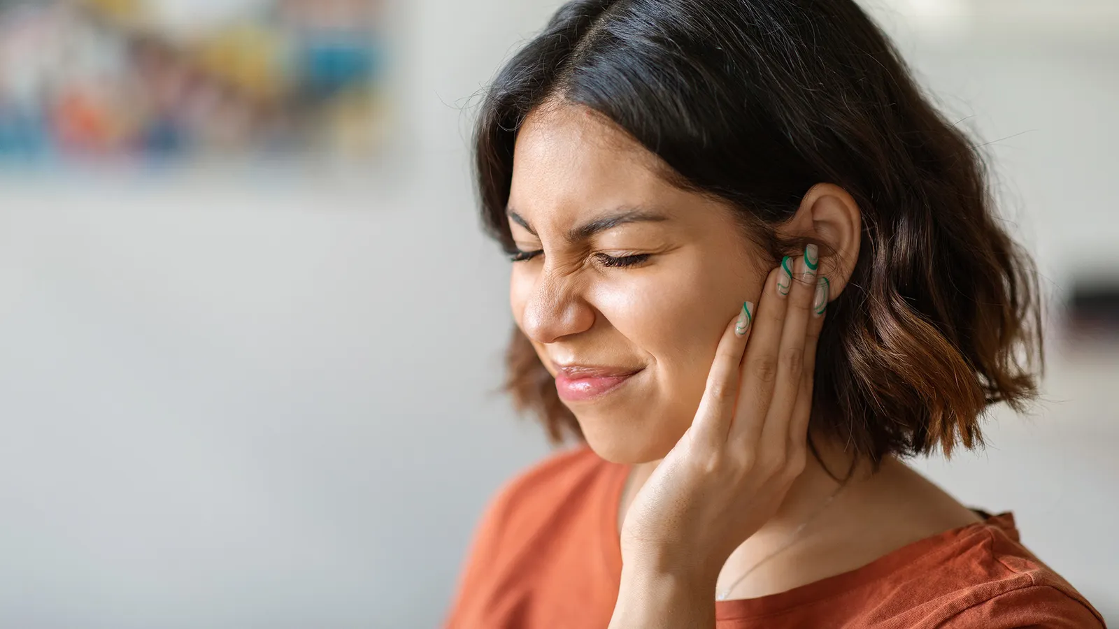 Frau hält sich wegen eines Tinnitus das Ohr