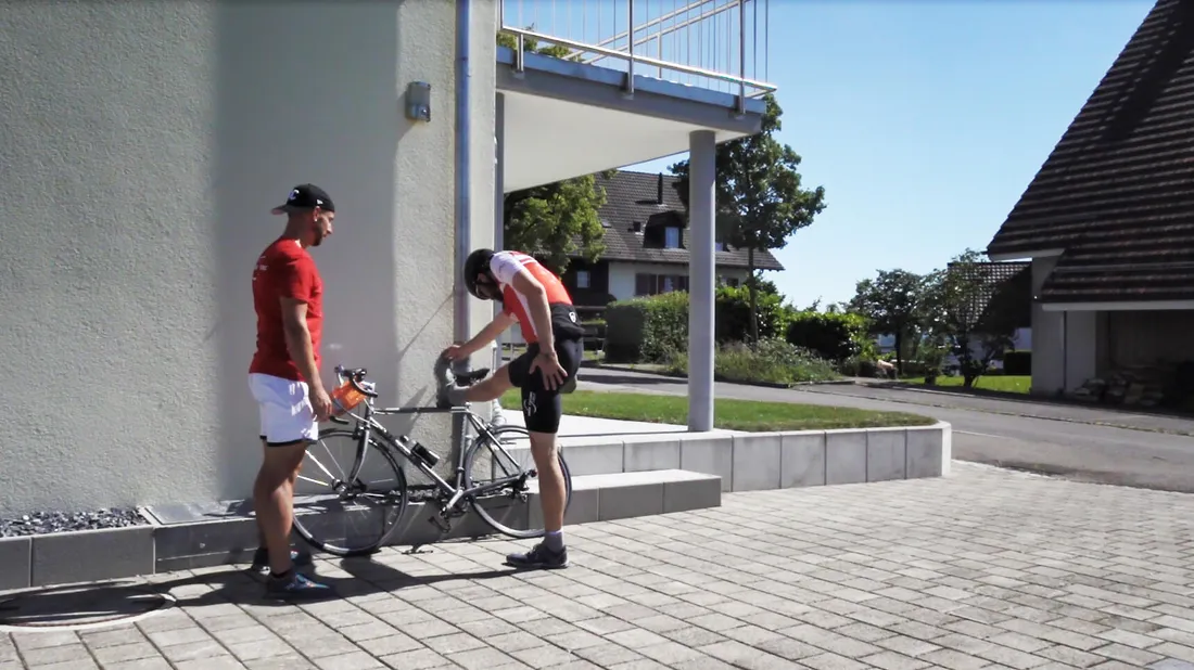 Zwei Radfahrer dehnen nach dem Training