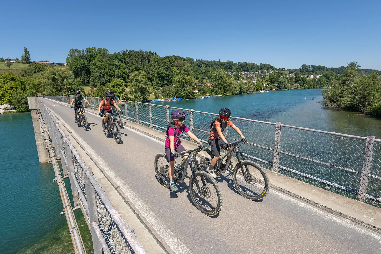 Familie auf Mountainbikes fährt über eine Brücke