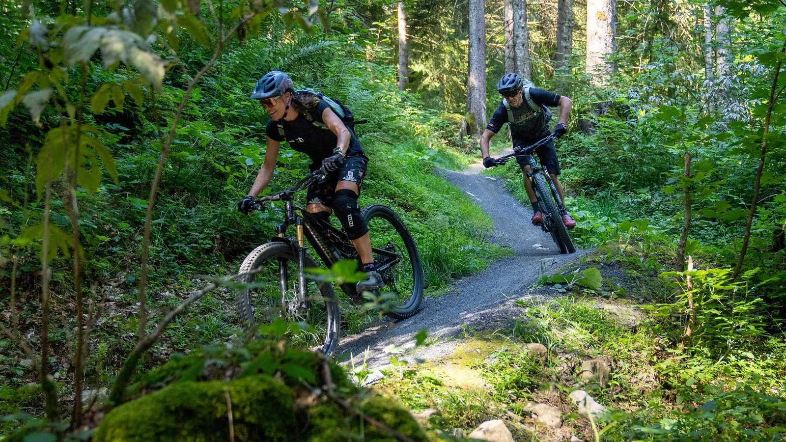 Zwei Mountainbiker auf einem Trail im Wald